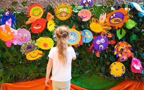 Girl looking at wall of children's artwork