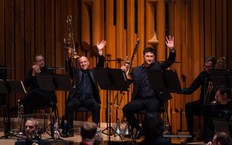 Orchestral musicians waving during a concert