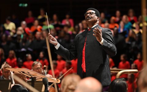 André J Thomas conducting the LSO, LSO Community Voices and LSC on the Barbican stage
