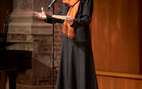a lady on stage giving a speech into a microphone