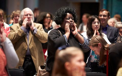 people in the audience touching their face with both hands