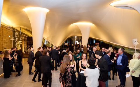 Crowd gathering for an evening event inside the Serpentine Gallery