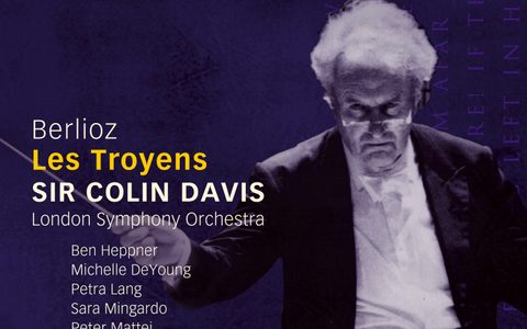 The album cover for Berlioz' Les Troyens, featuring a photo of Sir Colin Davis holding out his baton against a purple background.