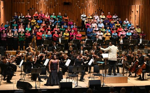 Wide shot of full orchestra and 250 voice choir in the Barbican Hall.