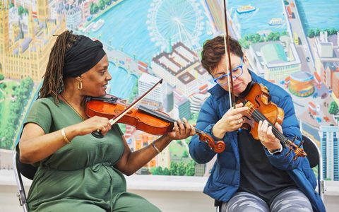 Two people playing violin