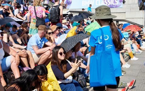 A volunteer speaking to audience members at BMW Classics 2023 in Trafalgar Square