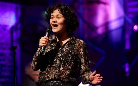 A young person singing with a microphone