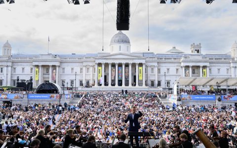 Duncan Ward conducting at BMW Classics with the audience and National Gallery behind him, framed by the stage.