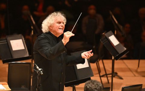 Sir Simon Rattle conducting on stage